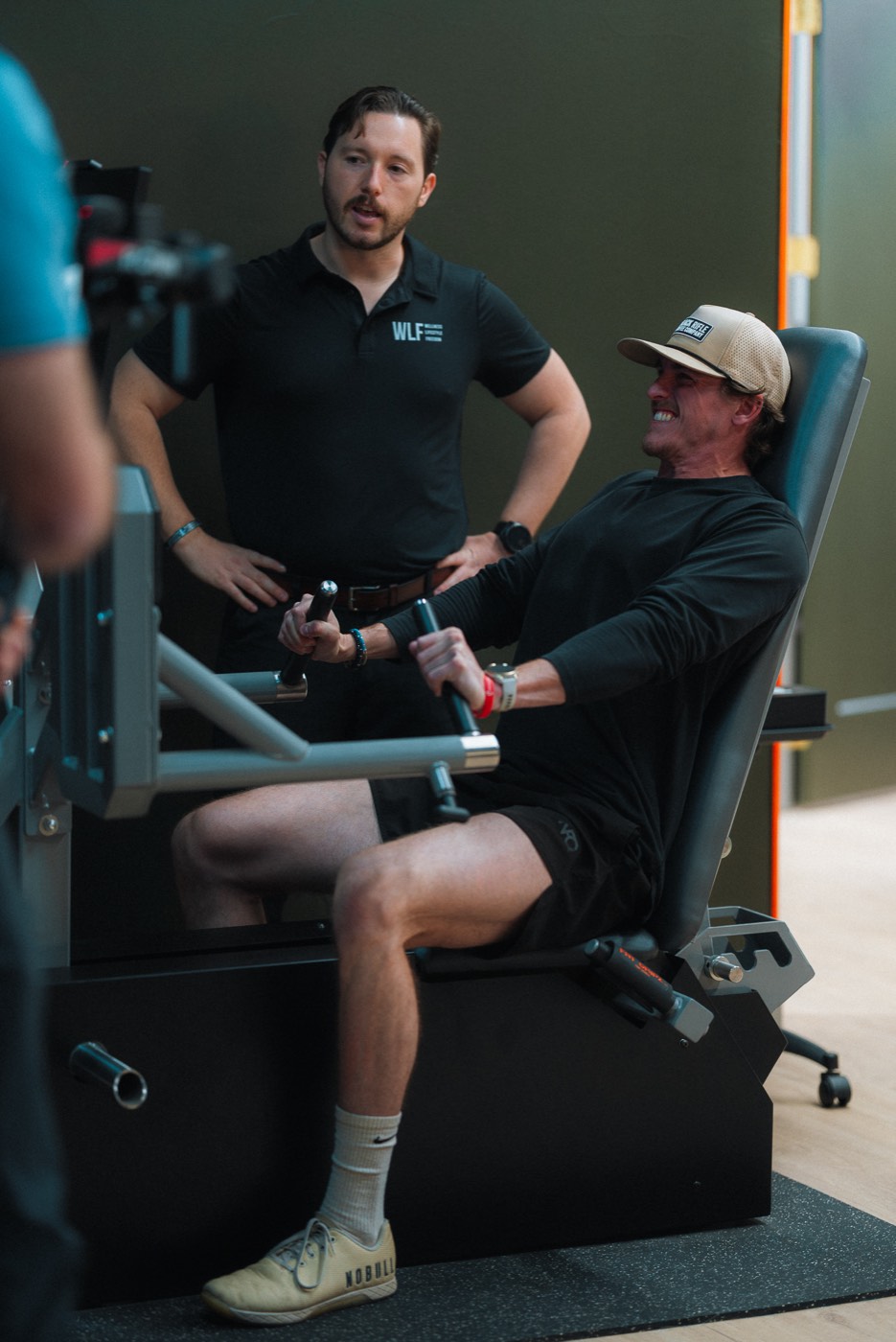 A WLF coach with a member mid-set on the ARX machine.