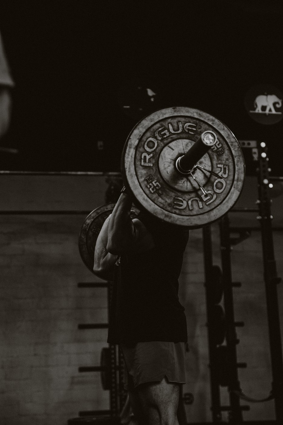 A member lifting on the training floor at WLF Club, shot as a dark silhouette.